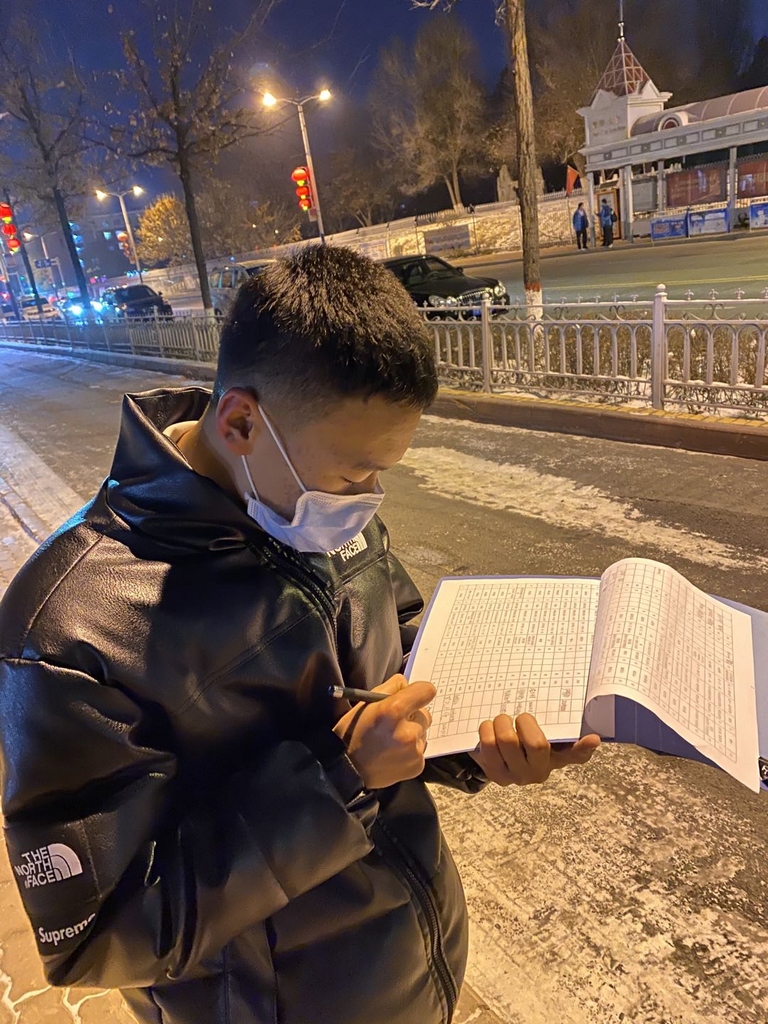 受助生马成虎夜间在路灯下填写签领表.jpg