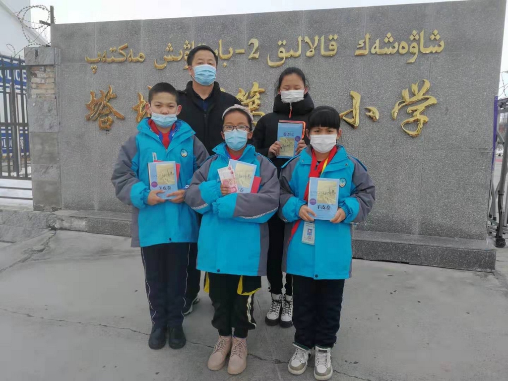 塔城市第二小学的受助生领取资助款和课外书籍后合影.jpg